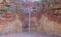 Im Hauptsaal konnten der originale Ziegelfußboden, Putzreste mit farbiger Bemalung im unteren Bereich und verwittertes Nischenmauerwerk freigelegt werden (Aufnahme 2002)