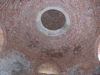 Das rekonstruierte Gewölbe des Hauptsaals mit seinem Opaeum aus Sandstein. Zwischen den Rundbogenöffnungen sind Reste vom Originalmauerwerk erkennbar (Aufnahme 2006)