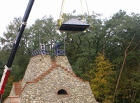 Ein Kran hebt das Dach des Pavillons auf die vormontierten Stützen (Aufnahme 2009)